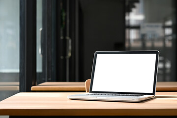 Wall Mural - Laptop with white empty screen on a wooden desk in modern office