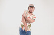 © Reezky - Upset Asian man wearing Hawaiian shirt and hat posing a rejection or stop hand gesture.