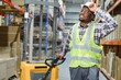 © Serhii - African american Man Driving Fork Lift Truck In Warehouse