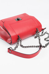 Wall Mural - New women's red bag with bronze fittings on a white isolated background. New collection of leather bags