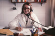 © fStop - Portrait smiling female doctor talking on telephone, working in clinic office