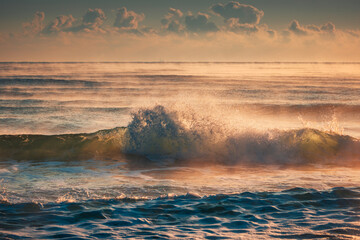 Wall Mural - Golden Morning Waves on a Tranquil Sea During Sunrise with Soft sunlight and rays