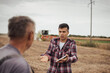 © Budimir Jevtic - Upset farmer in soybean field talking to other man during harvest