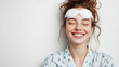 © Julia Zarubina - smiling young european woman in pajamas, with sleep mask on head on white background