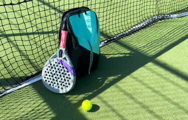 Wall Mural - Blue bag with tennis padel racket and ball on grassy field at tennis court, copy space. Unaltered, sport, competition, green, nature and summer concept.