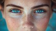 © imagineRbc - A woman with blue eyes and a freckled face. She has a blue eye shadow on her eyelids