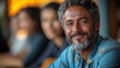 © anatolii - Smiling man with gray beard enjoying time in a relaxed cafe atmosphere with friends during a sunny afternoon