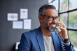 © Rido - Happy smiling mid adult indian businessman on call