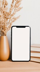 Poster - Modern smartphone with blank screen standing on wooden table next to vase with dried flowers and stack of books, showing website or app design mockup for advertising