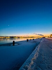 Wall Mural - Iced city river, winter city riverside at the twilights, ice on the river, night sky, illumination 