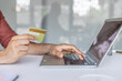 © Liubomir - Man with bank credit debit card and laptop, making online purchases, transferring money and booking services. Closeup photo of businessman hands inside office
