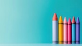 Six colorful crayons in row against teal background