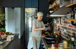 © Marko Geber - Senior woman cooking healthy meal in modern kitchen