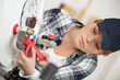 © auremar - young female plumber working on boiler with adjustable wrench