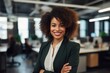 © Baba Images - Smiling portrait of a young African American businesswoman in modern office