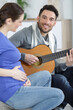 © auremar - boyfriend playing guitar to pregnant female