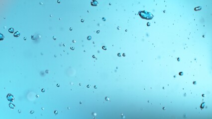 Wall Mural - Abstract Splash of Water on a Blue Background. Drops Isolated Flying in the Air.