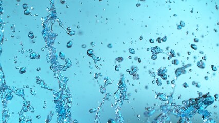 Wall Mural - Abstract Splash of Water on a Blue Background. Drops Isolated Flying in the Air.