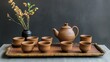 © somsri - A beautifully arranged tea set featuring a clay teapot, matching cups, and a bamboo tray