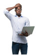 © Krakenimages.com - Young african american businessman using computer laptop stressed with hand on head, shocked with shame and surprise face, angry and frustrated. Fear and upset for mistake.