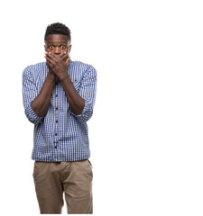 Wall Mural - Young african american man wearing blue shirt shocked covering mouth with hands for mistake. Secret concept.