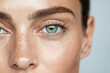 © Elisabeth Cölfen - Close-up of a young woman's freckled face and bright green eyes.