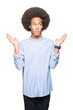 © Krakenimages.com - Young african american man with afro hair clueless and confused expression with arms and hands raised. Doubt concept.