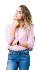 Beautiful young blonde woman over isolated background with hand on chin thinking about question, pensive expression. Smiling with thoughtful face. Doubt concept.