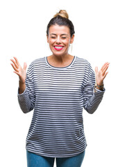 Wall Mural - Young beautiful woman casual stripes sweater over isolated background celebrating mad and crazy for success with arms raised and closed eyes screaming excited. Winner concept