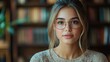 © melvilsky - Young woman wearing glasses poses for a portrait in a cozy library setting with warm lighting