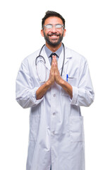 Wall Mural - Adult hispanic doctor man over isolated background praying with hands together asking for forgiveness smiling confident.