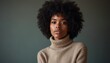 © natakot - A striking portrait of a confident Black woman with beautiful natural curls, wearing a soft beige turtleneck. Her serene expression and the muted green background create a captivating atmosphere of