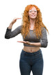 © Krakenimages.com - Young redhead woman gesturing with hands showing big and large size sign, measure symbol. Smiling looking at the camera. Measuring concept.