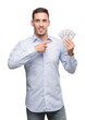 © Krakenimages.com - Handsome young man holding money very happy pointing with hand and finger