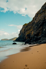 Wall Mural - A rocky beach with a cliff in the background