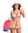 © Krakenimages.com - Young beautiful latin girl wearing bikini and hat holding bag annoyed and frustrated shouting with anger, yelling crazy with anger and hand raised