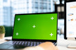 © DC Studio - Young business entrepreneur looking at green screen mockup on her gadgets, working in modern urban corporate office. Female leader developing a strategy to increase funding for success.