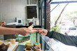 © Ana Luz Crespi/Stocksy - Anonymous hands exchanging money at take out window