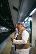 © Pedro Merino/Stocksy - Senior man using mobile while waiting for the subway