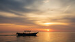 © Tonya - A serene boat floats calmly on tranquil waters under a dramatic sky at sunset, embodying peace and solitude.