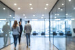 © Siasart - Blurred Photo of People Walking in a Modern Office Hallway with Glass Walls