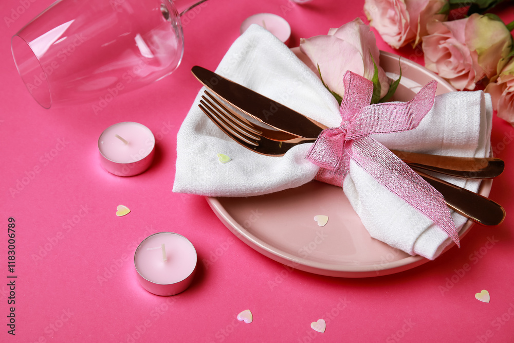 Table setting for Valentine's Day with roses and candles on pink background, closeup