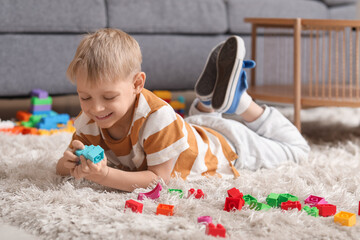 Canvas Print - Happy cute little boy playing with colorful toy bricks on floor at home