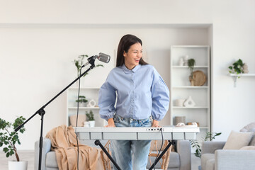 Wall Mural - Young woman playing synthesizer at home