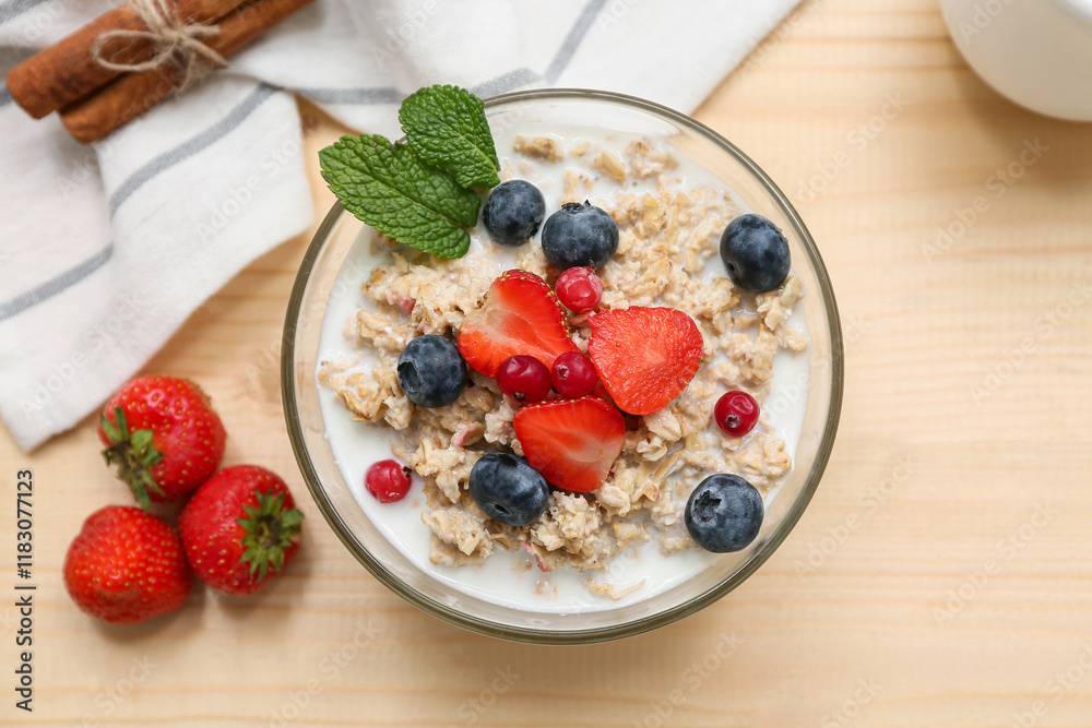 Composition with tasty oatmeal and berries on wooden background