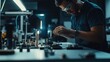 © STwul - Technician meticulously assembling components on a workbench in a dimly lit industrial setting.