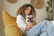 © PlanetOfVectors - Woman smiling while hugging a happy French bulldog, relaxing on a yellow chair in a cozy room. Warm, joyful atmosphere of companionship. Ai generative