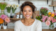 © siraphol - Cheerful woman smiling in floral shop surrounded by colorful flowers