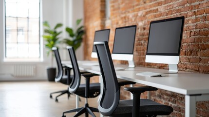Poster - Modern office interior featuring a row of computers on a shared desk, fostering collaboration and productivity