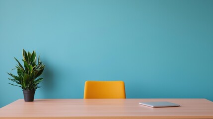 Poster - Minimalist home office with wooden desk, yellow chair and closed laptop against turquoise wall